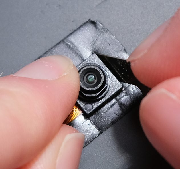 Now, carefully cut around the camera sensor part to remove its 'skirt' leaving tape on the back of it.