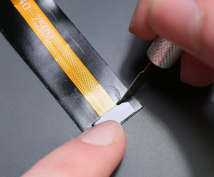 Begin to cut around the camera connector so the tape can be peeled off.