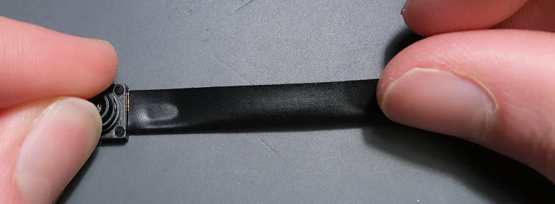 Begin to wrap the tape along the ribbon cable by first folding in the slightly shorter side.