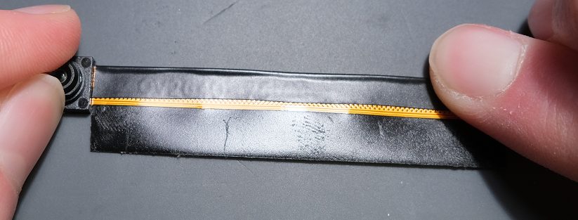 Begin to wrap the tape along the ribbon cable by first folding in the slightly shorter side.