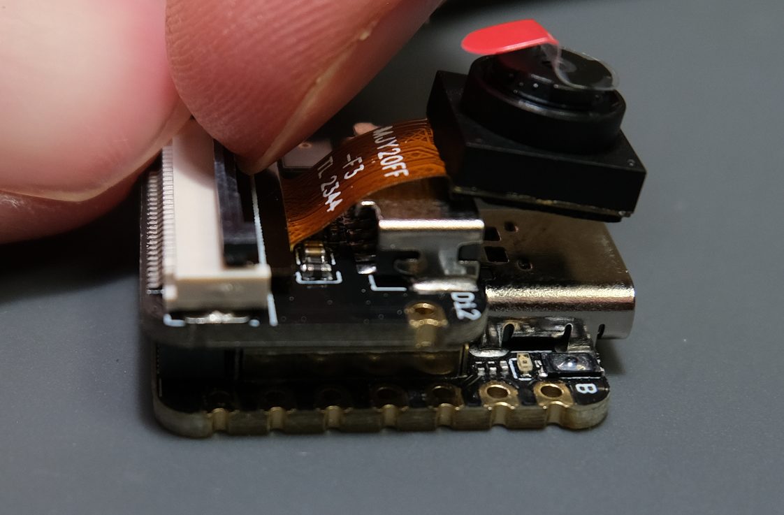 Begin by lifting up the grey part of the camera connector gently until it raises up.