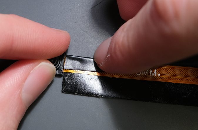 Begin to wrap the tape along the ribbon cable by first folding in the slightly shorter side.
